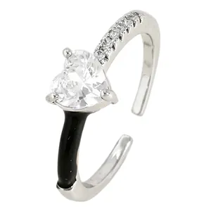 Close-up of silver open ring with heart-shaped clear zircon and black enamel detail