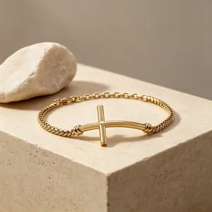 Detailansicht eines goldenen Edelstahl-Armbands mit horizontalem gebogenem Kreuz-Design.