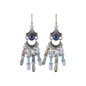 Boucles d'oreilles ethniques avec glands en cristal et motif œil protecteur bleu en argent.
