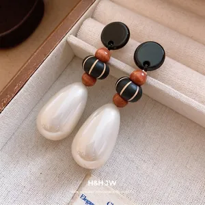 Elegant teardrop earrings featuring acrylic accents, wood beads, and white faux pearls