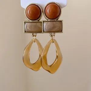 Vue détaillée de boucles d'oreilles pendantes géométriques en acrylique style rétro