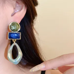 Gros plan sur des boucles d'oreilles géométriques rétro avec gouttes en acrylique tendance.