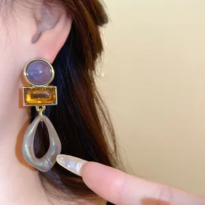 Gros plan détaillé de boucles d'oreilles pendantes géométriques en acrylique sur un mannequin