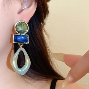 Gros plan détaillé de boucles d'oreilles pendantes géométriques en acrylique sur un modèle