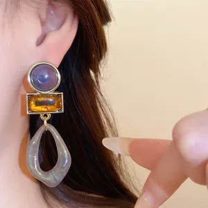 Gros plan de boucles d'oreilles pendantes géométriques en acrylique style Maillard