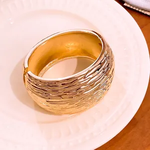 Elegant gold wide bangle bracelet with a sophisticated textured wrinkle surface finish