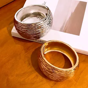 Textured gold and silver chunky metal bangles with crumpled water ripple pattern