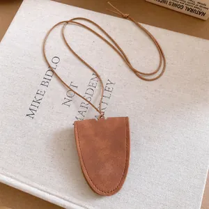 Minimalist brown leather glasses holder necklace detail with visible stitching on canvas