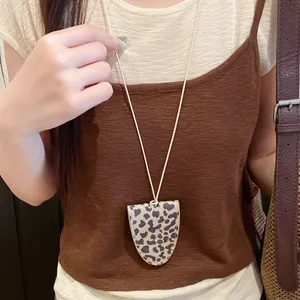 Detailed shot of a stylish leopard print leather glasses holder necklace on a model.