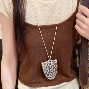 Detailed view of chic leopard print leather necklace pendant acting as an eyeglass holder
