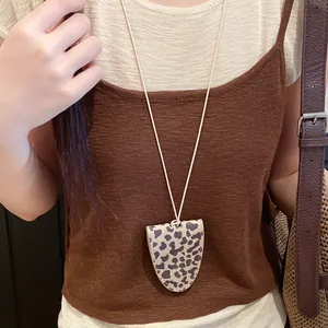 Close-up of a stylish leopard print leather glasses holder necklace worn by a model
