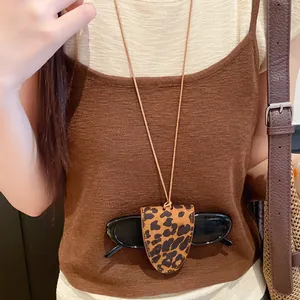 Close-up detail of a leopard print leather eyewear holder necklace on a brown sweater