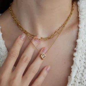 Nahaufnahme einer eleganten goldfarbenen mehrlagigen Titanstahlkette mit Zirkonia-Anhänger