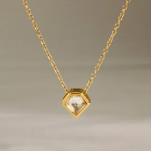 Nahaufnahme einer goldenen Halskette mit schildförmigem Anhänger und Zirkonia