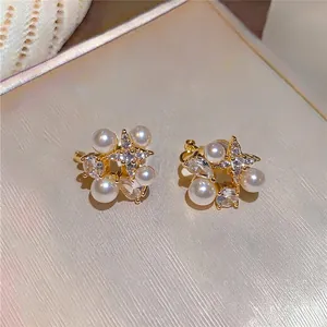 Close-up of 18k gold plated ear clips with pearls and sparkling zirconia details