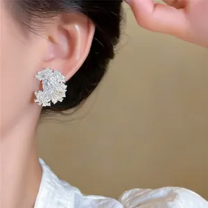 Macro view showing the fine texture of 18k gold plated pleated earrings with zircons
