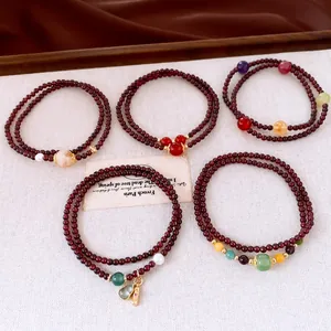 Detail of vintage garnet beaded bracelets with various colorful gemstones and charms