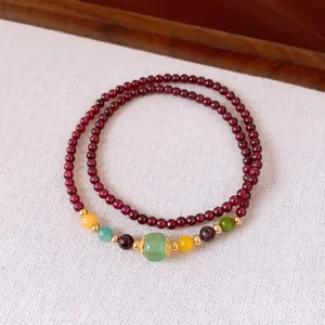 Detailed view of elegant double-strand garnet bracelet featuring vibrant gemstone accents