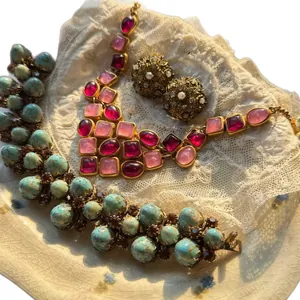 Vintage sieradenset met 14k vergulde kettingen en oorbellen op kanten achtergrond