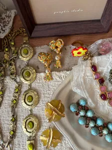 Close-up van een vintage 14k vergulde sieradenset met kleurrijke stenen en parels