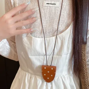 Detail einer braunen Brillenhalter-Halskette aus Leder mit Punkten an einem Model