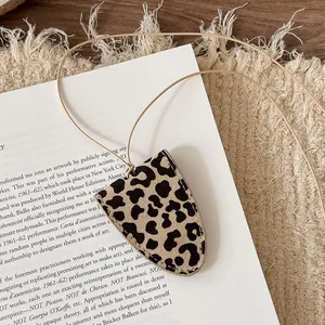 Detail shot of a chic leopard print leather glasses holder on a long tan cord