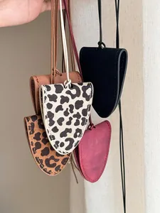 Detail view of four leather glasses holder necklaces in black, burgundy, and leopard print.