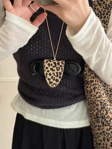 Detail of leopard print leather glasses holder necklace worn as a stylish accessory