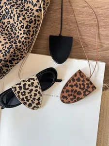 Detailed view of leopard print leather eyeglass holder necklace on a white magazine