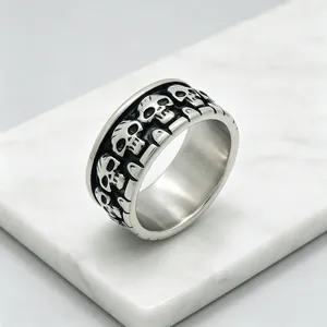 Gros plan d'une bague tête de mort en acier inoxydable avec gravures.