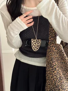 Detail view of a stylish leopard print leather eyewear holder necklace on a model's outfit