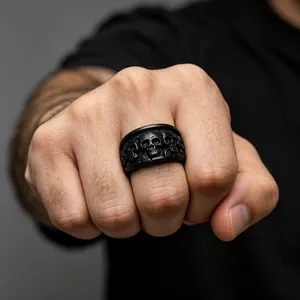 Gros plan d'une bague en acier inoxydable noir mat avec détails de crânes en relief