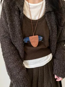 Minimalist brown leather glasses holder necklace worn as a stylish and functional sweater chain