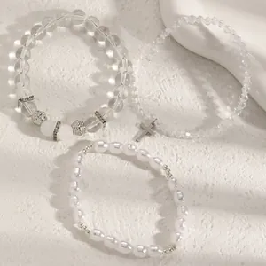 Detailansicht von Kristall- und Perlenarmband-Set mit silbernem Kreuzanhänger