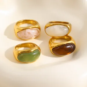 Vista detallada de cuatro anillos vintage de acero de titanio chapados en oro de 18K con acrílico.