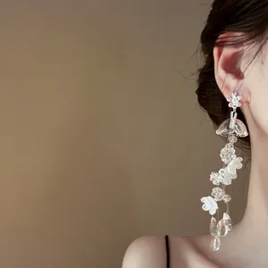 Boucles d'oreilles à pampilles muguet élégantes portées par un modèle sous lumière douce