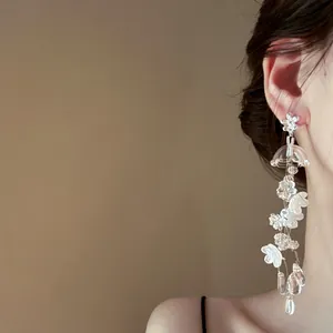 Gros plan de boucles d'oreilles pendantes à fleurs de muguet de style français chic