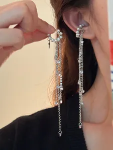 Nahaufnahme von eleganten Perlen- und Sternen-Quasten-Ohrclips an einem Ohr.