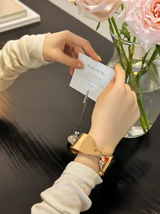 Detalle de una elegante pulsera de brazalete abierto geométrico en tono dorado