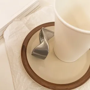 Primer plano macro de la textura mate suave de un brazalete metálico geométrico torcido