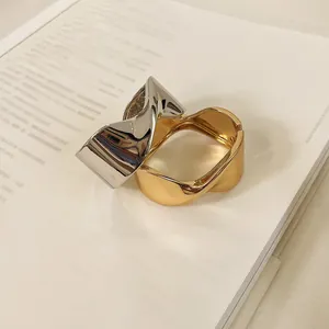 Brazalete abierto geométrico retorcido bicolor en acabado dorado y plateado.