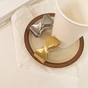 Detalle de brazaletes abiertos geométricos mate en acabados dorado y plateado