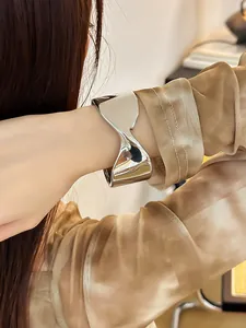 Primer plano de un brazalete plateado con elegante diseño geométrico en la muñeca