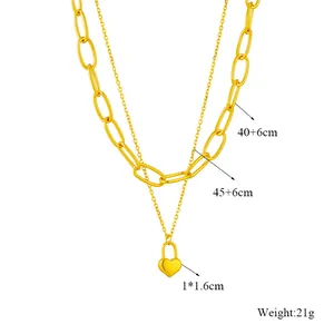 Detail view of gold double layered necklace showing chain lengths and heart lock dimensions.