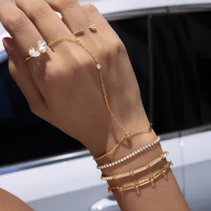 Détail d'un ensemble de bijoux en acier doré 18 carats avec bracelets et bagues en zircone