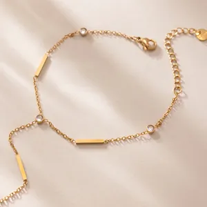 Détail d'un bracelet en acier inoxydable plaqué or 18 carats avec zircons et barres dorées
