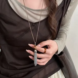 Detailed view of silver tassel beaded necklace with earth-toned stones in retro style