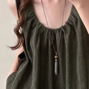 Detailed view of a silver tassel beaded necklace in New Chinese style on a model