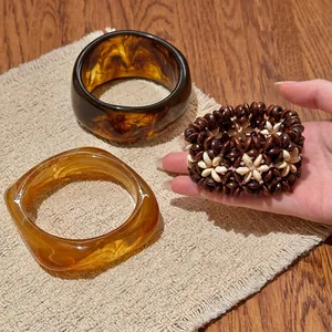 Vue détaillée de joncs en acrylique bohème et d'un bracelet en perles fait à la main