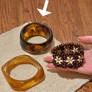 Vue détaillée des joncs rétro en acrylique et du bracelet floral en perles de bois